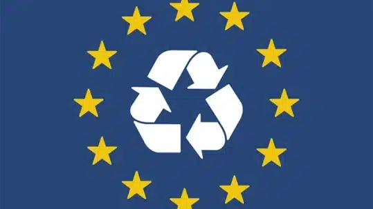Bandera de la Unión Europea con símbolo de reciclaje en el centro.
